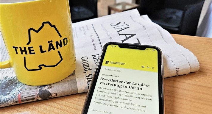 Newsletter auf Smartphone vor Zeitung