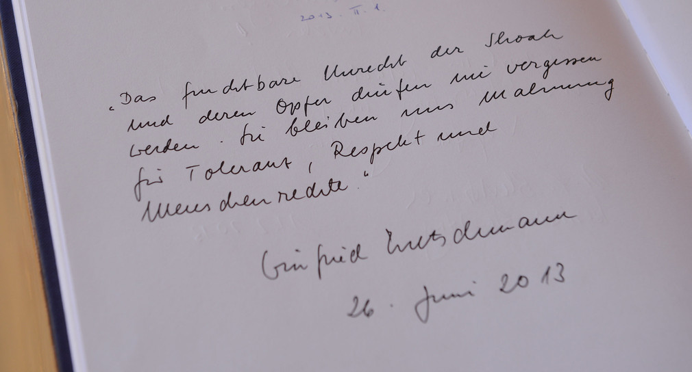 Winfried Kretschmann schreibt eine Widmung in das Gedenkbuch von Yad Vashem (Foto: dpa).