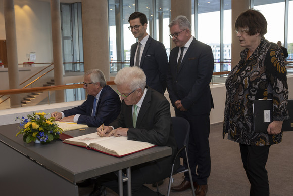 EU-Kommissionspräsident Jean-Claude Juncker (sitzend l.) und Ministerpräsident Winfried Kretschmann (sitzend r.) beim Eintrag in das Gästebuch des Landes und das Goldene Buch der Stadt Freiburg, dahinter stehen Freiburgs Oberbürgermeister Martin Horn (l.), der Minister der Justiz und für Europa, Guido Wolf (M.), und Staatsrätin Gisela Erler (r.) (Bild: Karl-Heinz Raach)