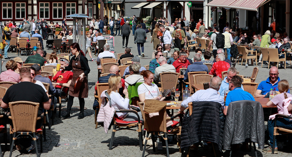 Touristen sitzen im Aussenbereich von Restaurants.