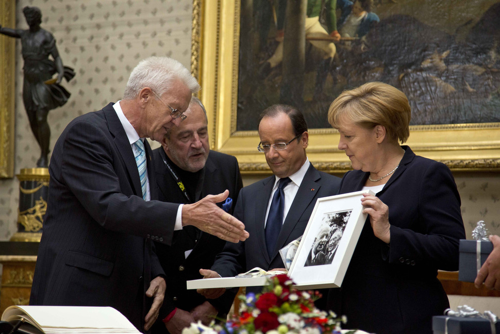 Ministerpräsident Winfried Kretschmann (l.) überreicht Staatspräsident François Hollande (2.v.r.) und Bundeskanzlerin Angela Merkel (r.) Geschenke (Foto: Staatsministerium Baden-Württemberg)