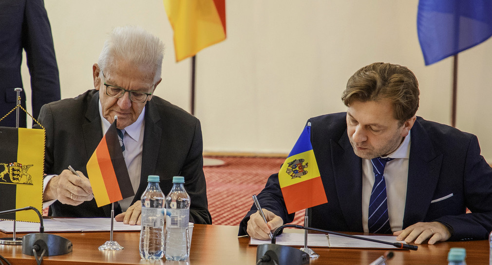 Ministerpräsident Winfried Kretschmann (links) und der stellvertretende von Molda Premierminister Dumitru Alaiba (rechts) unterzeichnen eine Absichterklärung. 