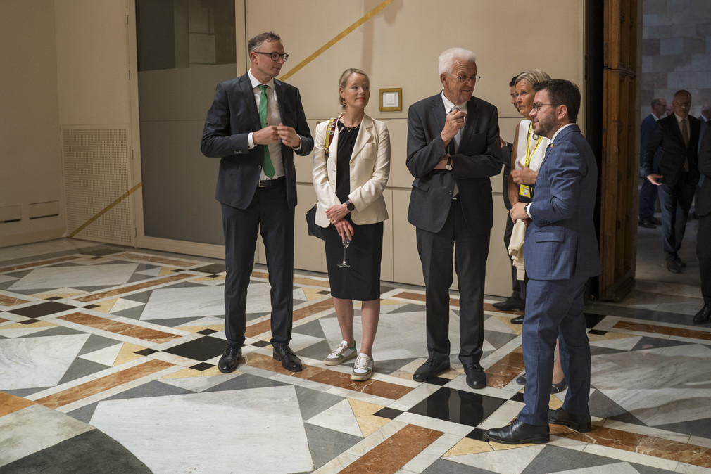 Kataloniens Regionalpräsident Pere Aragonès (rechts) im Gespräch mit Ministerpräsident Winfried Kretschmann (Dritter von links), Umweltministerin Thekla Walker (Zweite von links) und weiteren Vertreterinnen und Vertretern der baden-württembergischen Delegation.