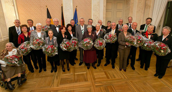 Gruppenbild der Ordensprätendeten mit Ministerpräsident Winfried Kretschmann (M.) und Justizminister Rainer Stickelberger (2. Reihe, l.)
