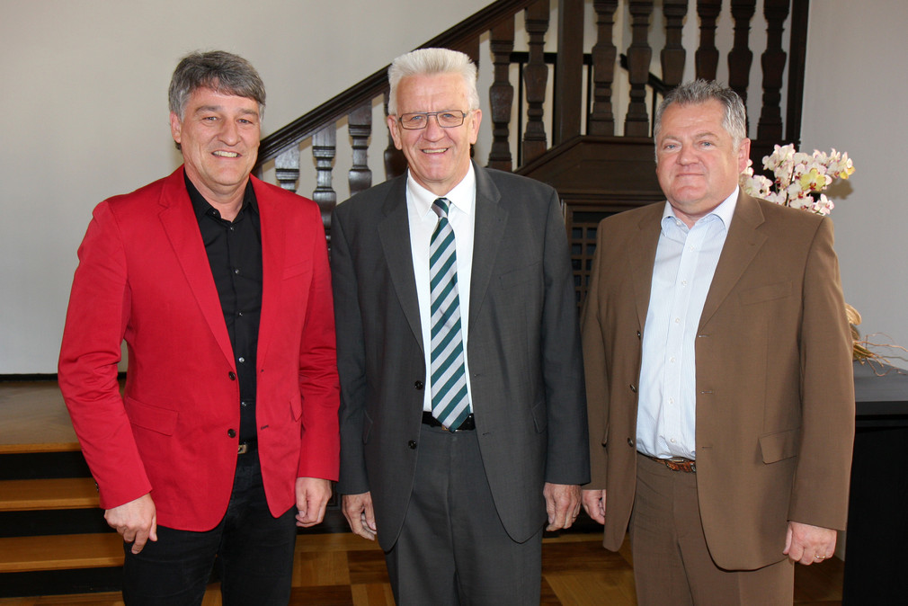 Ministerpräsident Winfried Kretschmann (M.) mit dem Präsidenten des VfB Stuttgart, Bernd Wahler (l.), und VfB-Vorstandsmitglied Ulrich Ruf (r.)