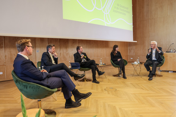 Podiumsdiskussion mit Prof. Dr. Markus Gabriel (links), The New Institute, Dr. Robert Habeck (Zweiter von links), Vizekanzler und Bundesminister für Wirtschaft und Klimaschutz, Moderator Peter Unfried (Mitte), Prof. Dr. Hedwig Richter (Zweite von rechts), Universität der Bundeswehr München, und Ministerpräsident Winfried Kretschmann (rechts)