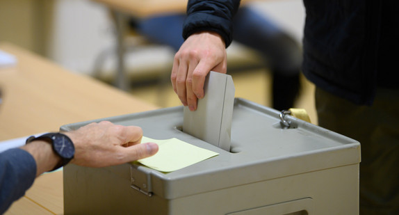 Ein Wähler wirft seinen Stimmzettel in eine Wahlurne.