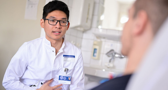 Ein Student im Praktischen Jahr am Universitätsklinikum Heidelberg spricht mit einem Patienten.