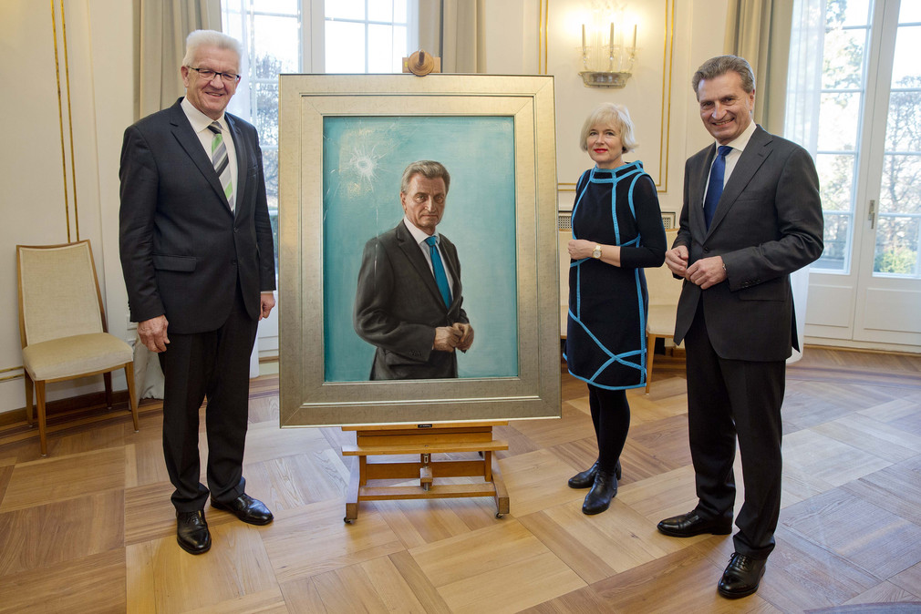v.l.n.r.: Ministerpräsident Winfried Kretschmann, die Künstlerin Anke Doberauer und der ehemalige Ministerpräsident Günther Oettinger stehen neben dem Porträt von Günther Oettinger. 