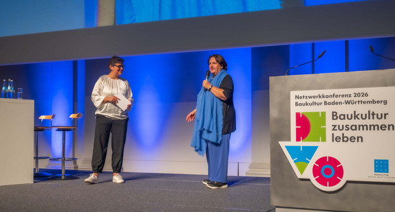 Ministerin Theresa Schopper (rechts) spricht zur Eröffnung der Netzwerkkonferenz Baukultur