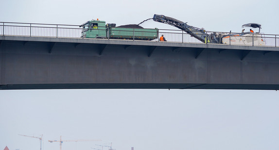 Ein Baufahrzeug hobelt auf der Salierbrücke in Speyer den Asphalt ab. Die Brücke ist eine wichtige Verkehrsverbindung zwischen Rheinland-Pfalz und Baden-Württemberg.