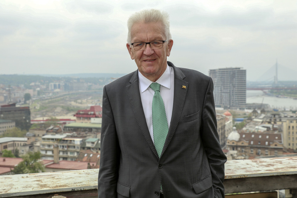 Ministerpräsident Winfried Kretschmann steht am 17. April 2018 im Rahmen einer Besichtigung eines Architekturprojekts in einem ehemaligen Bankgebäude vor dem Stadtbild von Belgrad