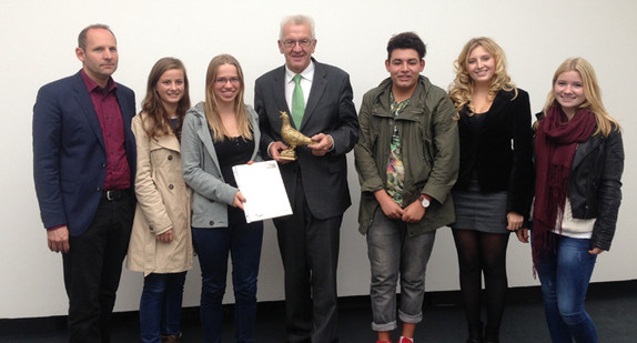 Ministerpräsident Winfried Kretschmann (M.) bekommt von Schülern des Stuttgarter Wagenburg-Gymnasiums eine Friedenstaube überreicht.