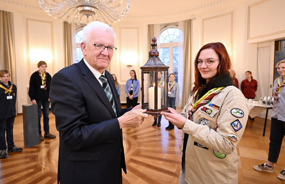 Jugendliche Pfadfinderinnen und Pfadfinder übergeben Ministerpräsident Winfried Kretschmann (links) das Friedenslicht aus Bethlehem.