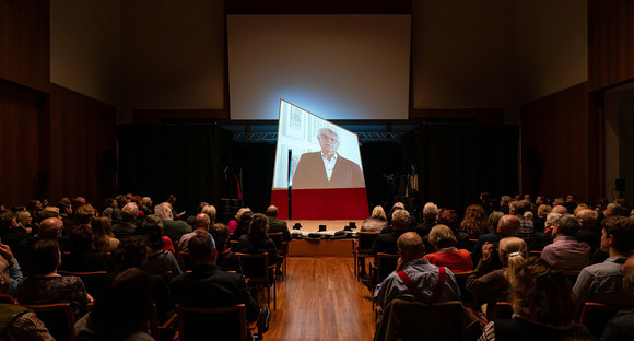 Staatssekretär Arne Braun begrüßt die Gäste via Video-Botschaft