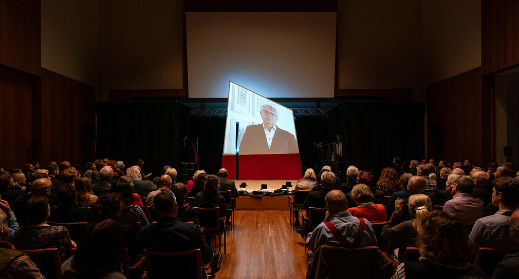 Staatssekretär Arne Braun begrüßt die Gäste via Video-Botschaft