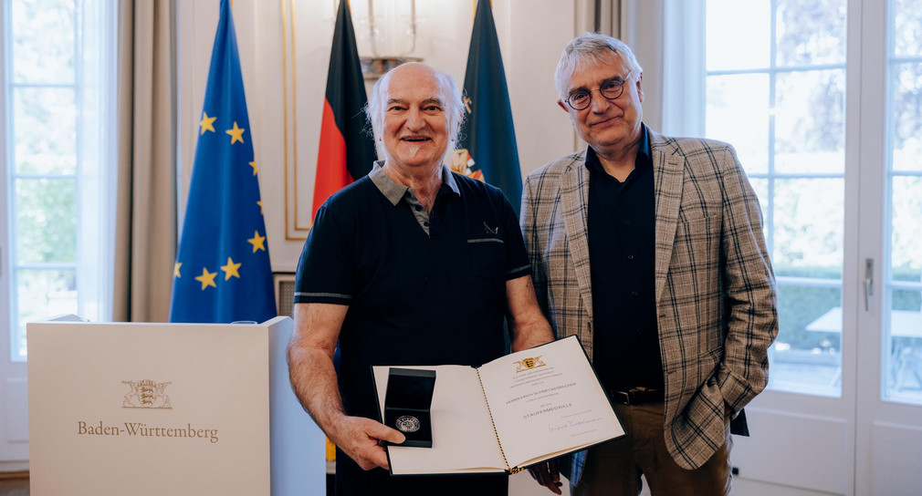 Kunststaatssekretär Arne Braun (rechts) und Erich Schmeckenbecher (links) mit der Staufermedaille und der Verleihungsurkunde.