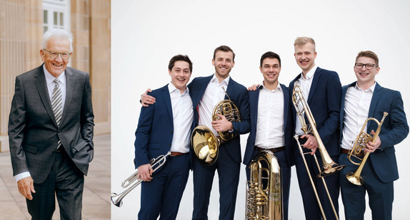 Links Ministerpräsident Winfried Kretschmann in einem grauen Anzug mit Krawatte: rechts die fünf Mitgliedern der Band Karidion Brass, die verschiedenen Blechblasinstrumente halten.