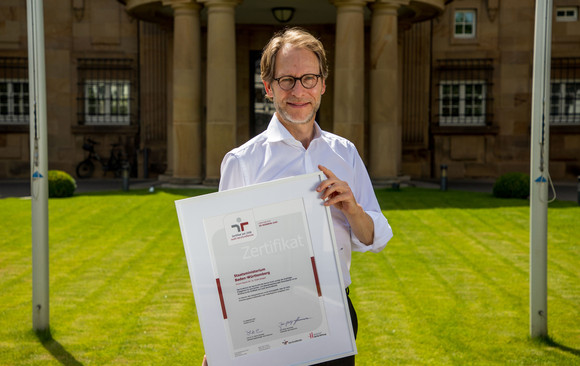 Staatsminister Dr. Florian Stegmann mit dem Zertifikat „audit berufundfamilie“ vor der Villa Reitzenstein in Stuttgart.