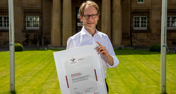 Staatsminister Dr. Florian Stegmann mit dem Zertifikat „audit berufundfamilie“ vor der Villa Reitzenstein in Stuttgart.