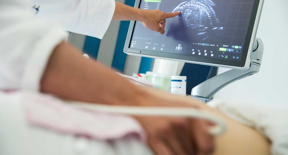 Ein Arzt einer Frauenklinik führt eine pränatale Ultraschall-Untersuchung an einer in der 18. Woche schwangeren Frau durch. (Bild: © picture alliance/Daniel Karmann/dpa) 