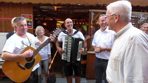 Kirchheimer Weindorf: Ministerpräsident Winfried Kretschmann (r.) mit Musikanten und Gästen