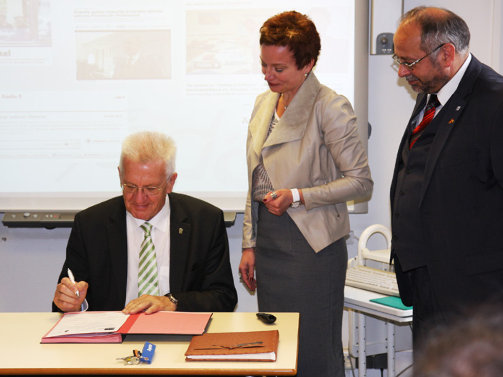 Ministerpräsident Winfried Kretschmann unterzeichnet einen Schulpartnerschaftsvertrag zwischen dem Land Baden-Württemberg und der Formacion Empresarial Dual Alemana (FEDA) zur Förderung der Dualen Ausbildung in Spanien.