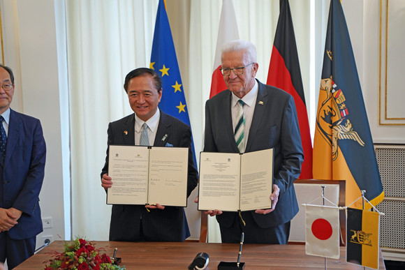 Ministerpräsident Winfried Kretschmann und Gouverneur Yuji Kuroiwa zeigen die unterzeichnete Gemeinsame Absichtserklärung zwischen Baden-Württemberg und Kanagawa. 