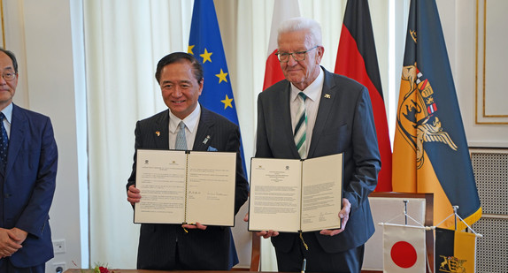 Ministerpräsident Winfried Kretschmann und Gouverneur Yuji Kuroiwa zeigen die unterzeichnete Gemeinsame Absichtserklärung zwischen Baden-Württemberg und Kanagawa. 