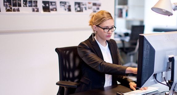 Businessfrau sitzt an einem PC