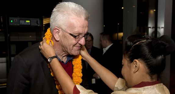 Eine Frau hängt Ministerpräsident Winfried Kretschmann in einem Hotel in Pune (Indien) eine Kette um (Foto: © dpa)