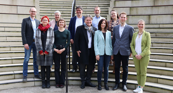Gruppenbild auf Treppe vor Landtag Baden-Württemberg: Sozialminister Manne Lucha mit Vertreterinnen und Vertretern der sechs „Housing First“-Modellprojekte.