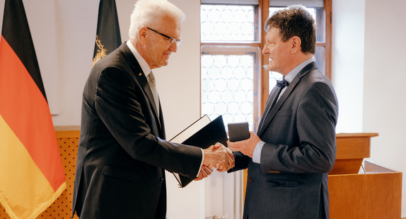 Ministerpräsident Winfried Kretschmann (links) überreicht Dr. Edwin Ernst Weber (rechts) die Staufermedaille des Landes Baden-Württemberg.