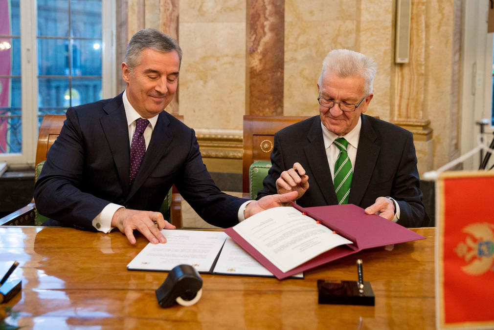 Ministerpräsident Winfried Kretschmann (r.) und der Ministerpräsident von Montenegro, Milo Đukanović (l.), bei der Unterzeichnung der Absichtserklärung über die künftige Zusammenarbeit zwischen Baden-Württemberg und Montenegro