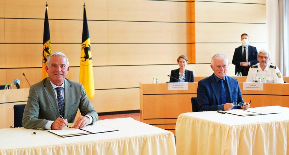 Stv. Ministerpräsident und Innenminister Thomas Strobl und Oberbürgermeister Fritz Kuhn unterzeichnen die Vereinbarung zur Sicherheitspartnerschaft.