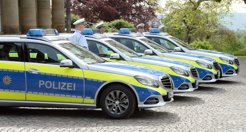 Polizisten stehen neben neuen Polizeifahrzeugen (Bild: Bernd Weißbrod / dpa)