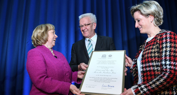 Die Staatsministerin im Auswärtigen Amt, Maria Böhmer (l.), überreicht die UNESCO-Weltkulturerbe-Urkunde „Höhlen und Eiszeitkunst der Schwäbischen Alb“ an Ministerpräsident Winfried Kretschmann (M.) und Wirtschaftsministerin Nicole Hoffmeister-Kraut (r.). (Foto: © dpa)