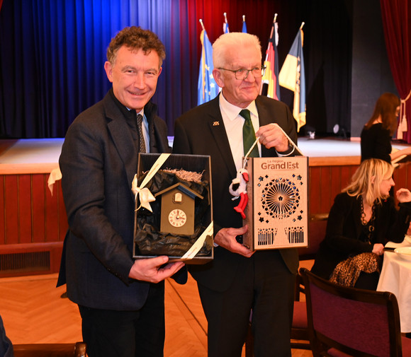 Ministerpräsident Winfried Kretschmann (rechts) und Franck Leroy (links), Präsident der Region Grand Est, beim Geschenkeaustausch.