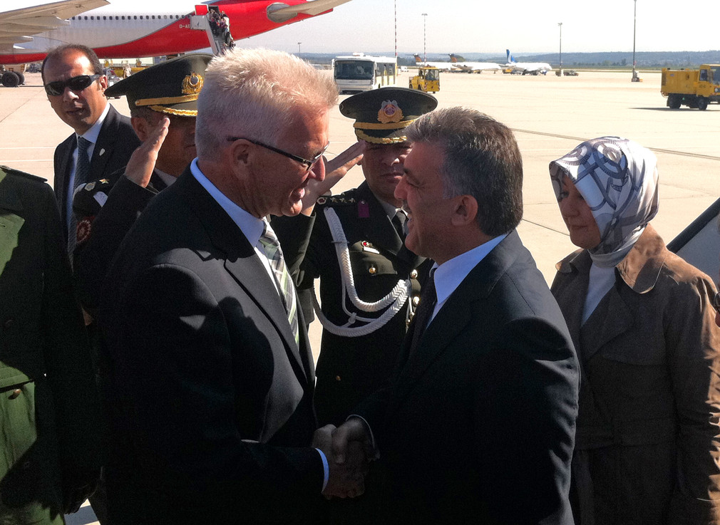 Ministerpräsident Winfried Kretschmann (l.) begrüßt den türkischen Staatspräsidenten Abdullah Gül (M.) und dessen Frau Hayrünnisa (r.) am Stuttgarter Flughafen