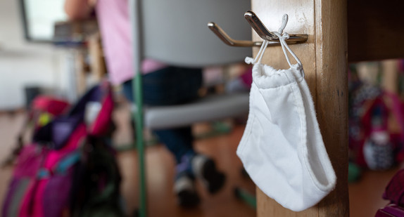 Ein Mund- und Nasenschutz hängt am ersten Schultag des neuen Schuljahres in einer Grundschule in Hemmingen an einem Haken. (Bild: picture alliance/Sebastian Gollnow/dpa)