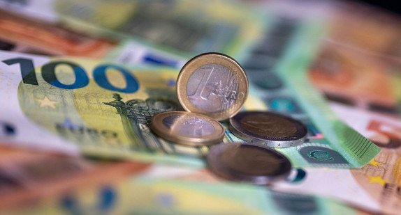 Geldscheine mit dem Wert von 100 und 50 Euro und Münzen liegen auf einem Tisch.