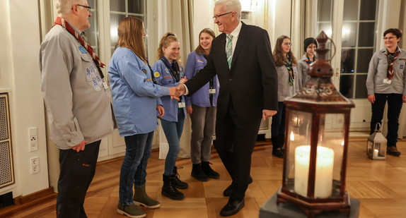 Ministerpräsident Winfried Kretschmann (Mitte) mit Pfadfinderinnen und Pfadfindern bei der Übergabe des „Friedenslichts“