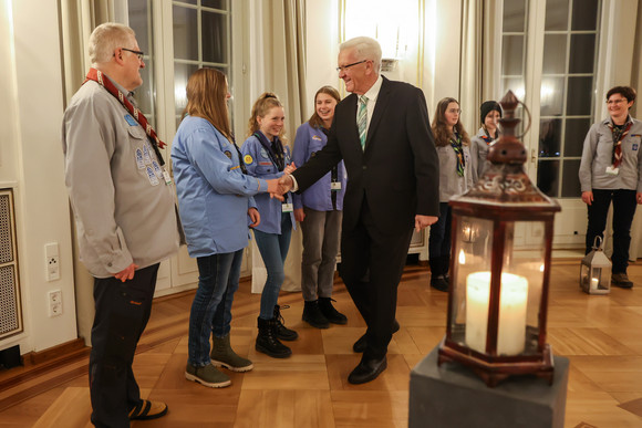 Ministerpräsident Winfried Kretschmann (Mitte) mit Pfadfinderinnen und Pfadfindern bei der Übergabe des „Friedenslichts“