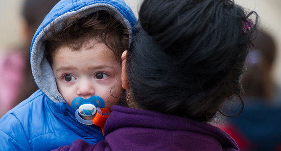 Eine Asylbewerberin trägt ihr kleines Kind auf dem Arm. (Bild: dpa)