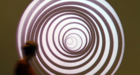 Eine Besucherin des Karlsruher Zentrum für Kunst und Medien (ZKM) geht an einer Video-Installation von Marcel Duchamp vorbei. (Bild: picture alliance/Uli Deck/dpa)