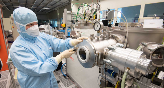 Eine wissenschaftliche Mitarbeiterin arbeitet im Reinraumlabor zur Herstellung von Mikrochips für Quantenprozessoren in der Physikalisch-Technischen Bundesanstalt PTB.