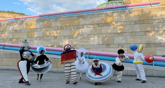 Personen in Figurenkostümen des Triadischen Balletts stehen vor der Staatsgalerie in Stuttgart.