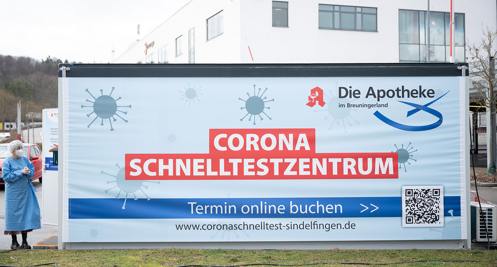 Ein Banner mit der Aufschrift Corona Schnelltestzentrum hängt an einem Container auf einem Parkplatz, auf dem sich das Testzentrum befindet. 