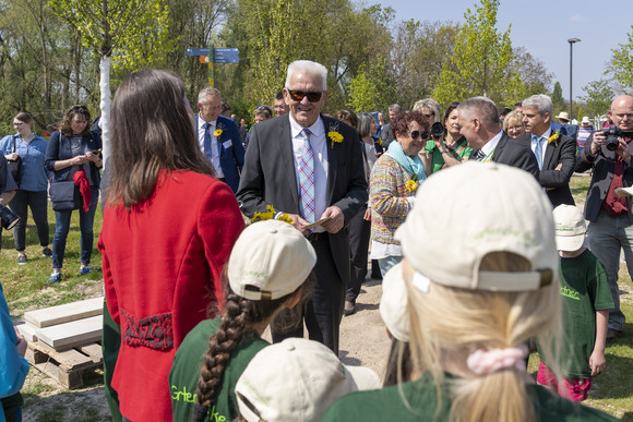 Ministerpräsident Winfried Kretschmann (Mitte) mit anderen Besucherinnen und Besuchern bei einem Rundgang auf der Landesgartenschau in Neuenburg am Rhein.