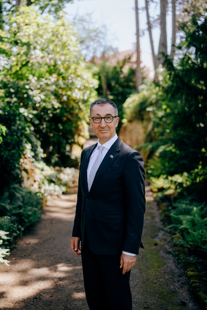 Portraitbild von Ministerpräsident Cem Özdemir, stehend im Park der Villa Reitzenstein.